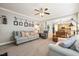 Cozy living room with a ceiling fan, soft carpet, and a comfortable sofa with decorative pillows at 112 Nelson Ln, Clayton, NC 27527
