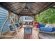 Outdoor patio with a metal awning, wooden porch swing, and stylish seating arrangements at 112 Nelson Ln, Clayton, NC 27527