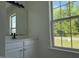 Bathroom featuring white cabinets, a modern mirror, and a large window at 118 Hawthorn Dr, Clayton, NC 27520