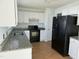Kitchen featuring granite countertops, white cabinets, and black appliances at 118 Hawthorn Dr, Clayton, NC 27520