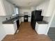 Bright kitchen with granite counters, wooden floors and black appliances at 118 Hawthorn Dr, Clayton, NC 27520
