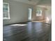 Sunlit living room featuring wood-look flooring and large windows at 118 Hawthorn Dr, Clayton, NC 27520