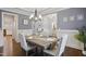 Elegant dining room featuring gray walls, wainscoting, a tray ceiling, and a chandelier at 1212 Sand Pine Dr, Cary, NC 27519