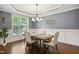 Elegant dining room featuring gray walls, wainscoting, a tray ceiling, and a chandelier at 1212 Sand Pine Dr, Cary, NC 27519