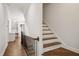 Hallway with hardwood floors, staircase with iron railing and built-in shelving at 1212 Sand Pine Dr, Cary, NC 27519