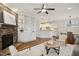 Open-concept living room featuring a stone fireplace, built-in shelves, and a view into the kitchen at 1212 Sand Pine Dr, Cary, NC 27519