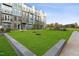 A modern townhome exterior and green lawn in the community create an inviting outdoor space for residents at 1238 Coach Station Aly # 101, Raleigh, NC 27601