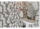 A powder room featuring patterned wallpaper, a pedestal sink, and modern fixtures and decor at 1238 Coach Station Aly # 101, Raleigh, NC 27601