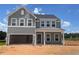 Charming two-story home featuring a welcoming porch and large open garage under a clear blue sky at 128 Sagamore Avenue, Angier, NC 27501