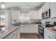 Well-lit kitchen with white cabinets, granite countertops, stainless steel appliances, and a window above the sink at 129 Sagamore Ave., Angier, NC 27501