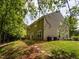 Exterior view of the house with a sloping backyard and wooded area at 1307 Montreux Ct, Mebane, NC 27302