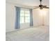Bright bedroom featuring neutral carpet, ceiling fan, and natural light from the window with blue curtains at 1307 Montreux Ct, Mebane, NC 27302