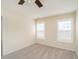 A bright bedroom with beige walls, carpet, and two windows with white shutters at 1307 Montreux Ct, Mebane, NC 27302