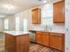Well-equipped kitchen with stainless steel appliances, wood cabinets, an island, and a view into the main living area at 1307 Montreux Ct, Mebane, NC 27302