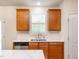 Bright kitchen featuring stainless steel appliances, wood cabinets, a central island and a sink with a window at 1307 Montreux Ct, Mebane, NC 27302