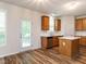 Well-lit kitchen featuring stainless steel appliances, wood cabinets, a central island, and access to the outdoor area at 1307 Montreux Ct, Mebane, NC 27302