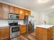 Well-lit kitchen with stainless steel appliances, wooden cabinets, and a bright white countertop island at 1307 Montreux Ct, Mebane, NC 27302