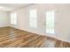 Sunlit living room with lovely flooring, white trim, and windows offering natural light and a back patio door at 1307 Montreux Ct, Mebane, NC 27302