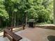 Outdoor patio with grill and built-in bench surrounded by lush trees at 1307 Montreux Ct, Mebane, NC 27302