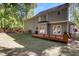 View of the backyard featuring a wooden deck, lush green lawn, and mature trees at 141 Clay Ridge Way, Holly Springs, NC 27540