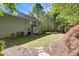 Well-maintained backyard featuring a lush lawn, mature trees, and a charming stone pathway at 141 Clay Ridge Way, Holly Springs, NC 27540