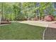 Well-manicured backyard featuring a lush lawn and landscaped garden beds with mature trees at 141 Clay Ridge Way, Holly Springs, NC 27540
