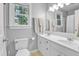 Bright bathroom featuring a double sink vanity, window and neutral decor at 141 Clay Ridge Way, Holly Springs, NC 27540