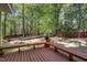 Inviting wooden deck with built-in benches, overlooking the serene, tree-filled backyard at 141 Clay Ridge Way, Holly Springs, NC 27540