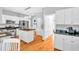 Open kitchen with stainless steel appliances, an island with granite countertops, and wooden floors at 141 Clay Ridge Way, Holly Springs, NC 27540