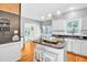 Open kitchen with stainless steel appliances, an island with granite countertops, and wooden floors at 141 Clay Ridge Way, Holly Springs, NC 27540