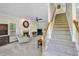 Living room featuring a fireplace, staircase, neutral walls, and carpet at 141 Clay Ridge Way, Holly Springs, NC 27540