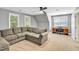 Spacious living room features a large sectional sofa, bright windows and ceiling fan at 141 Clay Ridge Way, Holly Springs, NC 27540
