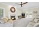 Bright living room featuring a cozy fireplace, neutral furniture, and a ceiling fan at 141 Clay Ridge Way, Holly Springs, NC 27540