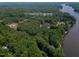 Aerial view of a property nestled among lush trees near the water at 1412 Sagamore Dr, Louisburg, NC 27549