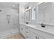 Modern bathroom features a double sink vanity with quartz countertop and walk-in shower with decorative tile at 1412 Sagamore Dr, Louisburg, NC 27549