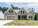Charming green two-story home featuring a two-car garage and well-manicured lawn at 1412 Sagamore Dr, Louisburg, NC 27549