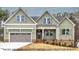 Charming two-story home with sage green siding, attached two-car garage, and inviting front porch at 1412 Sagamore Dr, Louisburg, NC 27549