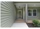 Covered front porch with modern light fixture and well manicured landscaping at 1412 Sagamore Dr, Louisburg, NC 27549