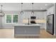 Spacious kitchen island featuring white cabinets, stainless appliances, and pendant lighting at 1412 Sagamore Dr, Louisburg, NC 27549