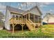 View of the home's rear exterior featuring a spacious screened porch and wooden deck at 1412 Sagamore Dr, Louisburg, NC 27549