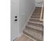 Carpeted staircase with a wood handrail leads to the upper level at 1412 Sagamore Dr, Louisburg, NC 27549