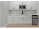 A wet bar featuring white cabinets, stainless steel appliances, and a neutral backsplash at 1412 Sagamore Dr, Louisburg, NC 27549