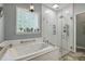 Relaxing bathroom with large tub, glass shower, and bright window at 146 Bennett Pl, Clayton, NC 27527