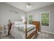 Cozy bedroom featuring a classic wooden bed frame and soft, natural light from two windows at 146 Bennett Pl, Clayton, NC 27527