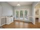 Breakfast nook with wainscoting, light blue walls, wooden floors, and white French doors at 146 Bennett Pl, Clayton, NC 27527