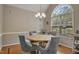 Dining room with vaulted ceiling, chandelier, large window, round wooden table and upholstered chairs at 146 Bennett Pl, Clayton, NC 27527