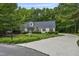Charming home with a long driveway, well-maintained lawn, and a variety of flowering plants in a lush green setting at 146 Bennett Pl, Clayton, NC 27527