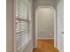 Hallway showing hardwood floors, a window with closed blinds, and white molding at 146 Bennett Pl, Clayton, NC 27527