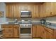 Kitchen featuring stainless steel appliances, wood cabinets, and tile backsplash at 146 Bennett Pl, Clayton, NC 27527