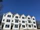 Newly constructed townhomes displaying contemporary farmhouse design against a blue sky at 1538 Crescent Townes Way, Raleigh, NC 27604